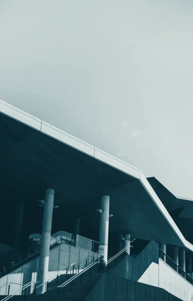The angular roof and columns of a modern building against the sky